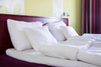 una cama con almohadas blancas encima en Hotel Salora, en Salo