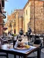 a table with a plate of food and a bottle of wine at Hotel Spa QH Centro León in León