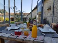 a wooden table with food and drinks on a patio at Les Hauts De Chalonne in Le Gond-Pontouvre