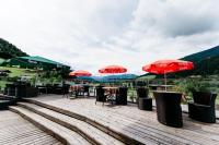 a group of tables and chairs with umbrellas on a deck at Landhotel Berger in Eben im Pongau