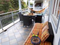 a porch with a hammock and a table and chairs at Appartement à la Résidence LA PLANTATION RESORT and SPA in Saint-François