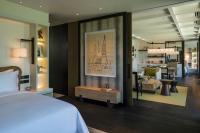 a bedroom with a bed and a living room at Rosewood Phuket in Patong Beach