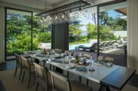 a dining room with a long table and chairs at Rosewood Phuket in Patong Beach