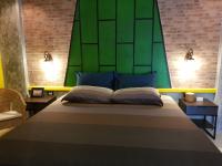 a bedroom with a large bed with a green headboard at Baan Baimai Boutique Room in Phra Nakhon Si Ayutthaya