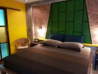 a bedroom with a bed with a green headboard at Baan Baimai Boutique Room in Phra Nakhon Si Ayutthaya