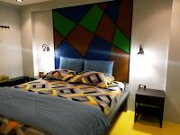 a bedroom with a large bed with a colorful headboard at Baan Baimai Boutique Room in Phra Nakhon Si Ayutthaya