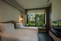 a bedroom with two beds and a large window at Rosewood Phuket in Patong Beach
