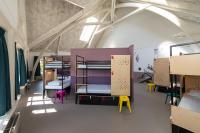 a room with bunk beds and colorful chairs at Stayokay Hostel Amsterdam Vondelpark in Amsterdam