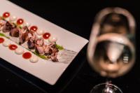 un plato de comida junto a una copa de vino en Hotel Colón Gran Meliá - The Leading Hotels of the World, en Sevilla