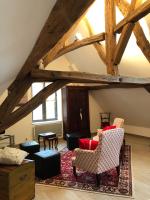 an attic living room with wooden beams and chairs at Aux Cornettes in Beaune