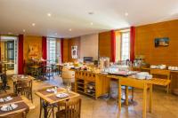a restaurant with tables and chairs and a kitchen at Domaine De Barres in Langogne