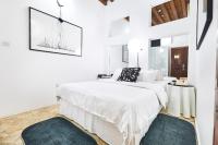 ein weißes Schlafzimmer mit einem Bett und zwei Teppichen in der Unterkunft XVA Art Hotel in Dubai