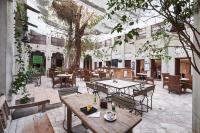 einen Innenhof mit Tischen, Stühlen und einem Baum in der Unterkunft XVA Art Hotel in Dubai