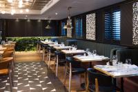 Un restaurante con mesas y sillas en una sala. en Hotel Du Vin Stratford, en Stratford-upon-Avon