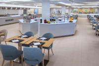 a restaurant with tables and chairs and a kitchen at Mediterraneo Bay Hotel & Resort in Roquetas de Mar