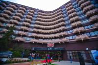 Un gran edificio con gente parada afuera. en Premier Alatau Hotel, en Almaty
