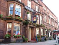 a brick building with flowers in front of it at The George Hotel in Penrith
