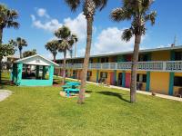ein Gebäude mit Palmen davor in der Unterkunft South Beach Inn - Cocoa Beach in Cocoa Beach