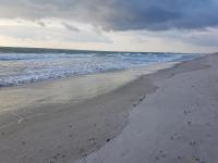ein leerer Strand mit Fußabdrücken im Sand und im Ozean in der Unterkunft South Beach Inn - Cocoa Beach in Cocoa Beach