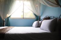 a bed in a blue bedroom with a window at Raid Garden Boutique Hotel in Magong