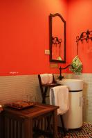 a bathroom with orange walls and a sink and a table at Raid Garden Boutique Hotel in Magong
