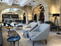a lobby with chairs and tables and a bar at Boutique Hôtel des Remparts & Spa in Aigues-Mortes