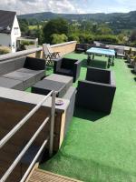 a patio with chairs and a table and grass at Le Loft in Stoumont