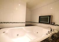 a large white bath tub with a tv in a bathroom at Shihzuwan Hotel – Kaohsiung Station in Kaohsiung