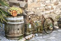 an old bike parked next to a wooden barrel at La Bergerie De Valerie in Arthès