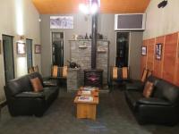 sala de estar con 2 sillas de cuero y chimenea en Stations Inn, en Hokitika