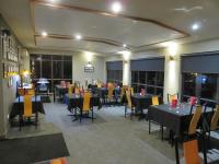 Un comedor con mesas y sillas en un edificio. en Stations Inn, en Hokitika