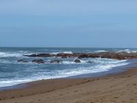 a sandy beach with rocks in the ocean at Grain de Sable et son Jacuzzi in Talmont