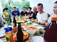 un grupo de personas sentadas alrededor de una mesa comiendo pizza en Megabe Villa, en Galle