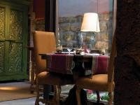una mesa con 2 sillas y una lámpara y copas de vino en Inkaterra La Casona Relais & Chateaux, en Cusco