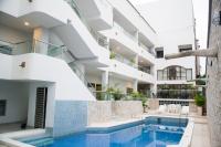 Una vista exterior de un edificio con piscina. en Hotel Dorado BAQ, en Barranquilla