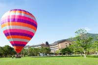 a colorful hot air balloon flying over a field at Luminous Hot Spring Resort &amp; SPA in Luye