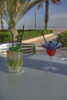 Una mesa con una bebida y una copa de martini encima. en Hotel Neptuno Playa & Spa, en Valencia