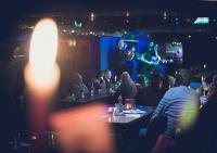 a group of people sitting in a bar watching a performance at Arlington Hotel O'Connell Bridge in Dublin