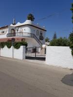 a white house with a balcony on a street at DesyMar Inn in Fontane Bianche