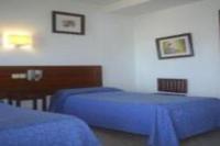 a bedroom with two blue beds and a desk at Hotel Marina Victoria in Algeciras