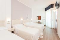 A bed or beds in a room at Hotel Roxy & Beach