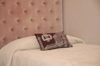 a pillow on a bed with a pink headboard at Hôtel de L&#39;Avenue in Saintes