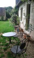 a patio with a table and chairs in a yard at la vigneraie in Seigy