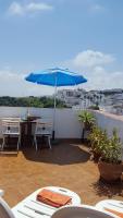 a patio with a blue umbrella and a table and chairs at Holiday home La Atalaya de Vejer in Vejer de la Frontera