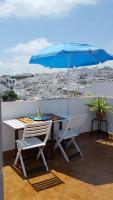 a table and chairs with an umbrella on a balcony at Holiday home La Atalaya de Vejer in Vejer de la Frontera