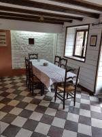 a dining room with a table and chairs on a checkered floor at Le Logis De Judicael in Paimpont