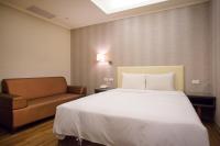 a hotel room with a bed and a couch at Garden Hotel in Taichung