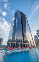 a tall building with a pool in front of it at Canal Central Hotel Business Bay in Dubai