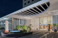 Un gran edificio con palmeras delante. en Intercity Ribeirão Preto, en Ribeirão Preto