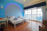 a bedroom with two beds and a large window at Lighthouse B&amp;B in Dahan